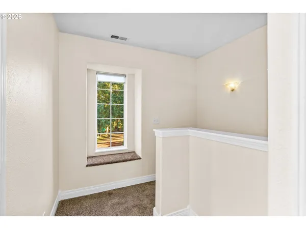 a view of a hallway with wooden floor and bathroom