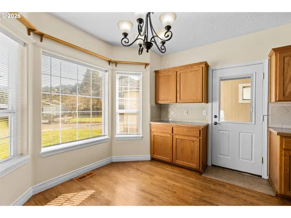 a kitchen with granite countertop a sink cabinets stainless steel appliances and a large window