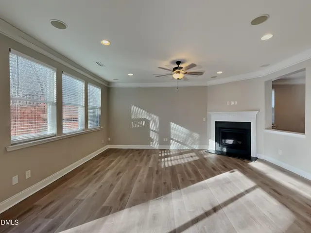 a view of an empty room with a fireplace and a window