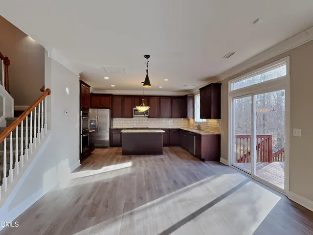 a large kitchen with a large counter top stainless steel appliances and cabinets