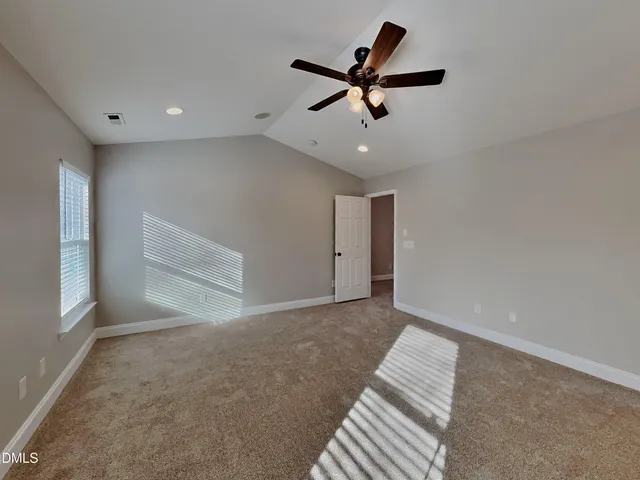 an empty room with a ceiling fan and a window