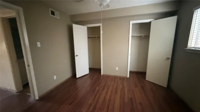 an empty room with wooden floor and entrance