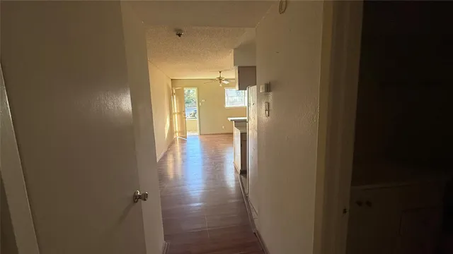 a view of a hallway with wooden floor