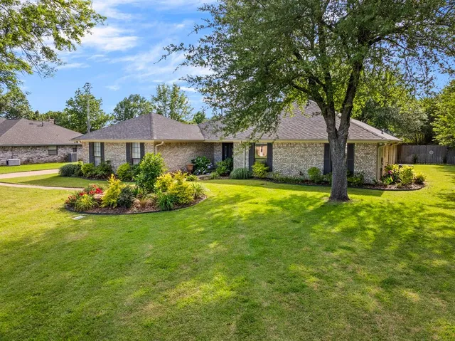 a view of a house with a big yard and potted plants