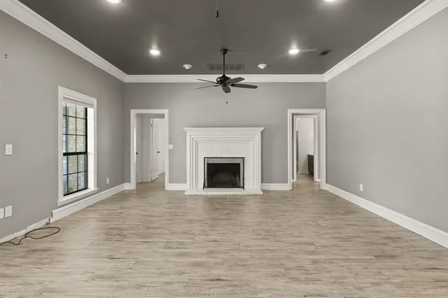 wooden floor fireplace and windows in an empty room