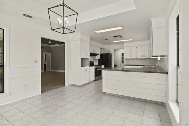 a view of kitchen with stainless steel appliances cabinets and a window