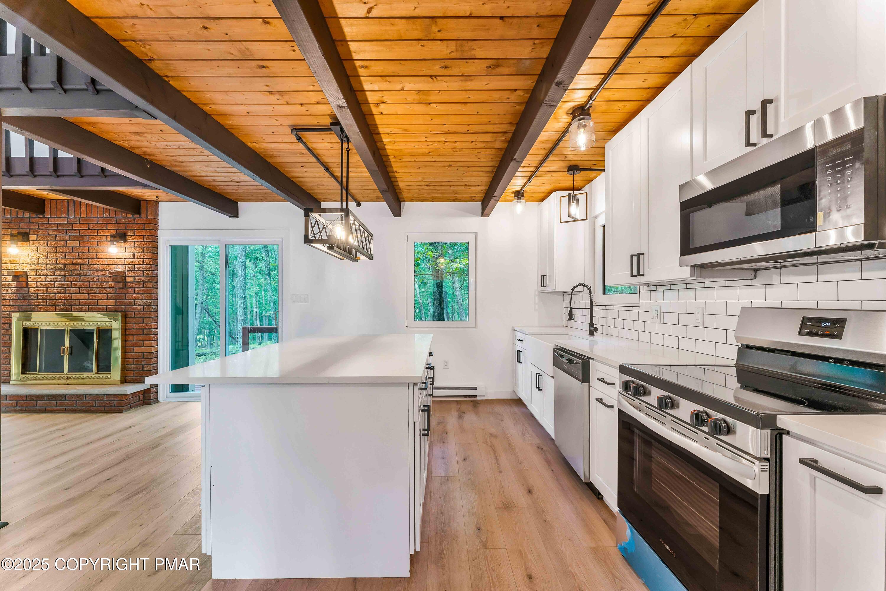 151 Elgin Way Bushkill, PA 18324 - Photo 20 of 60 a kitchen with stainless steel appliances a stove a sink a microwave oven and a wooden floors