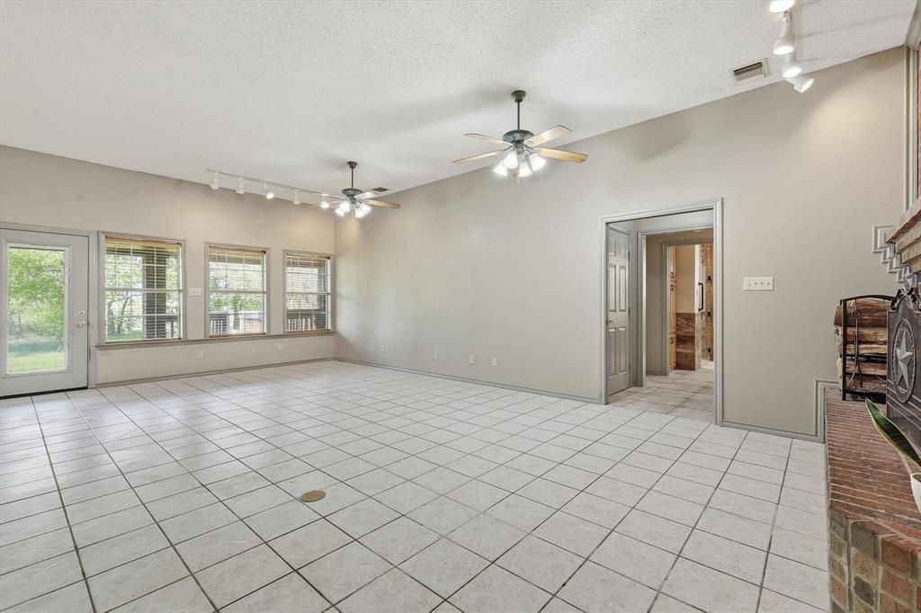 135 Private Road 2202 Decatur, TX 76234 - Photo 3 of 40 Spare room with track lighting, light tile patterned flooring, a textured ceiling, and ceiling fan