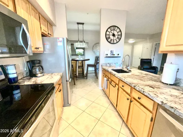 a kitchen with kitchen island granite countertop a sink a stove and cabinets