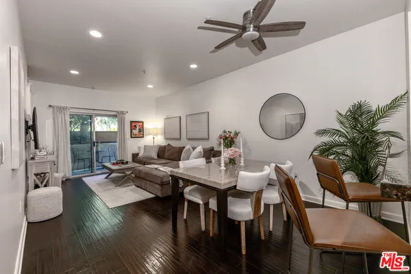 a living room with furniture kitchen view and a large mirror