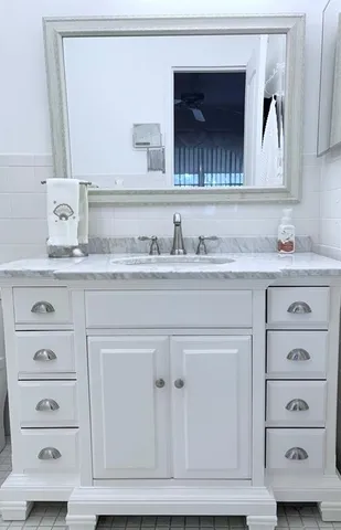 a bathroom with a sink vanity and a mirror