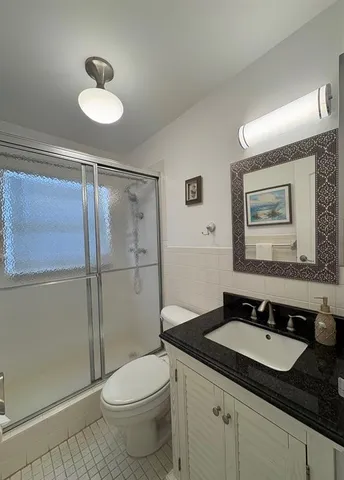 a bathroom with a granite countertop sink toilet and shower