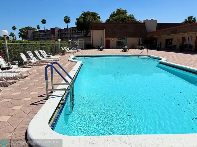 a view of a house with chairs and potted plants