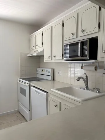 a kitchen with stainless steel appliances granite countertop white cabinets a sink and dishwasher