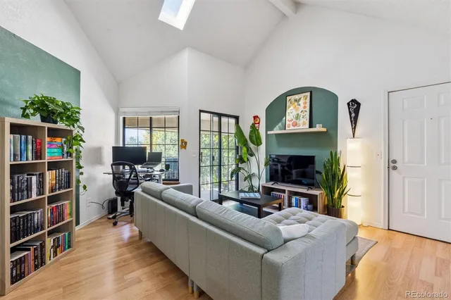 a living room with furniture a flat screen tv and a book shelf