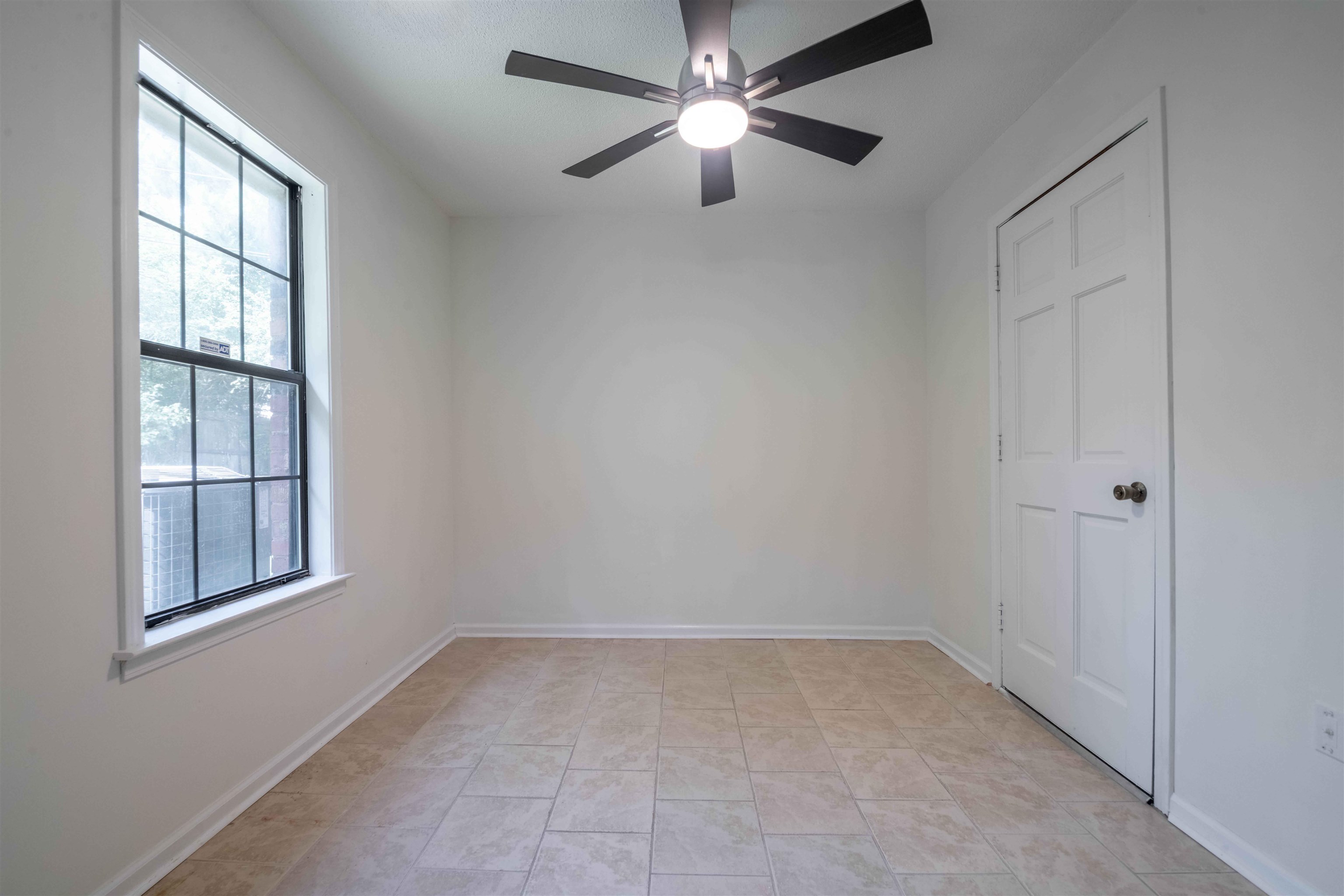 7800 Buck Ridge Cove Memphis, TN 38016 - Photo 19 of 36 Neutral wall finishes featuring a grid-paned window, tile flooring, and a ceiling fan with integrated lighting