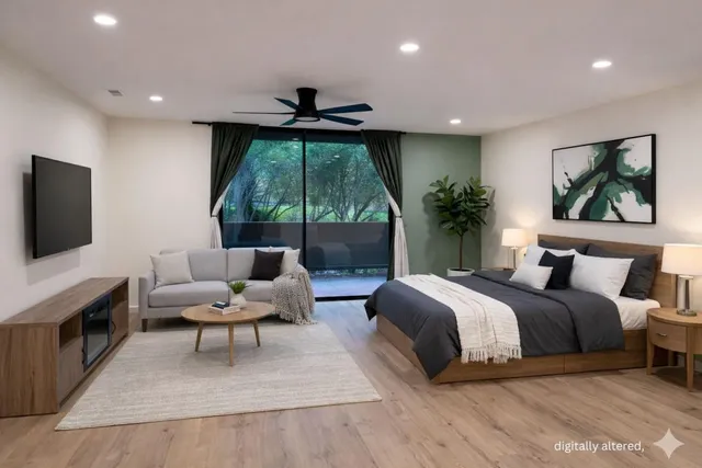 a spacious bedroom with a bed and a flat screen tv