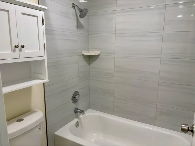 a bath tub sitting next to a white toilet and a sink