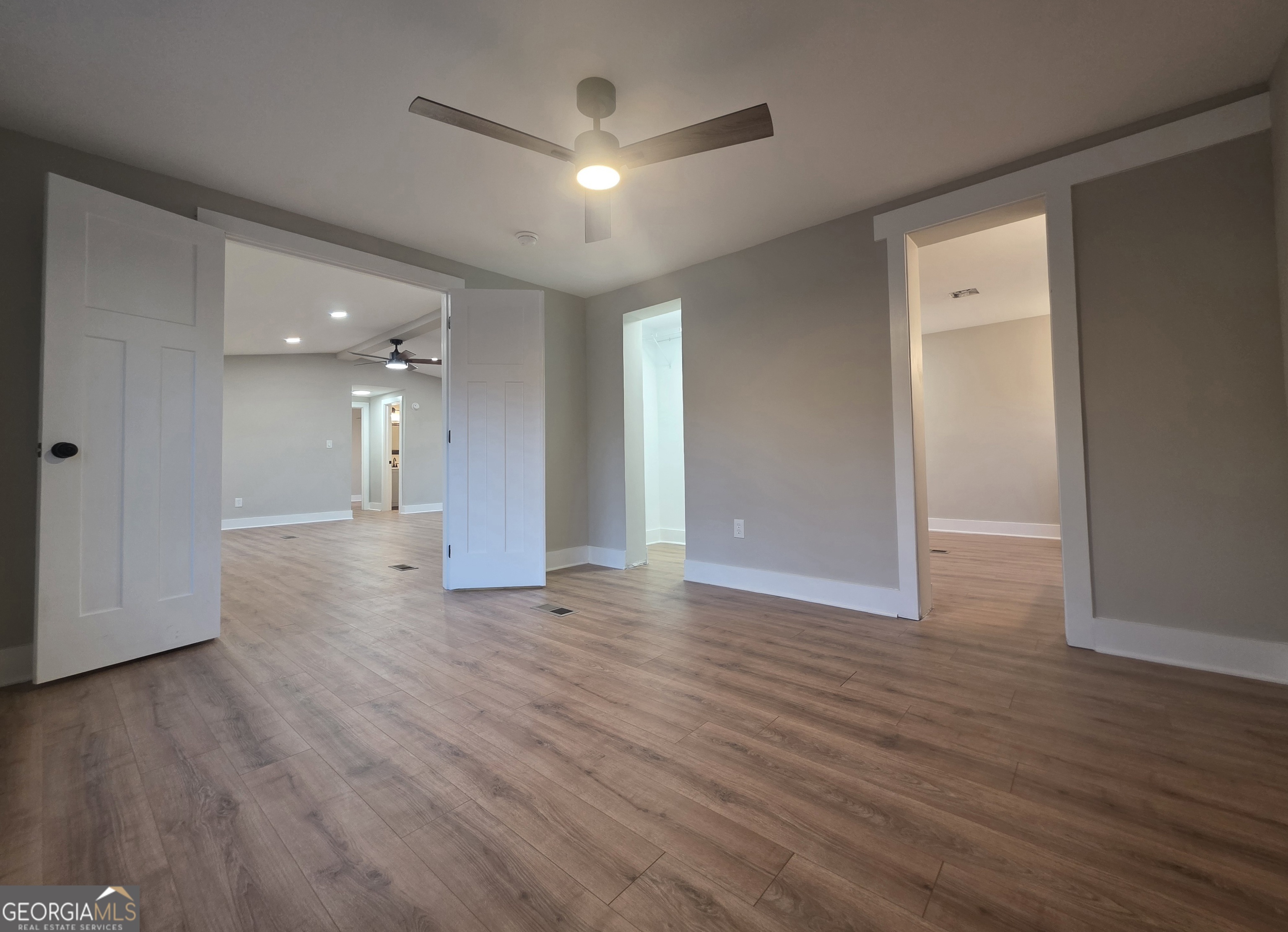115 Little Street Williamson, GA 30292 - Photo 8 of 9 a view of an empty room with wooden floor and a ceiling fan