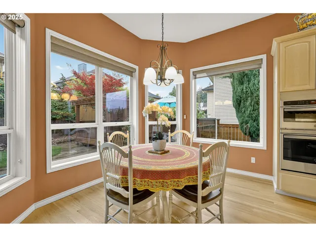 a dining room with furniture large windows and wooden floor