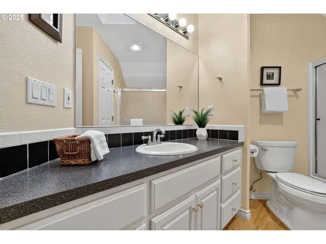a bathroom with a granite countertop sink mirror and toilet