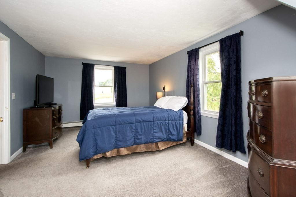 3 Battery Road Hull, MA 02045 - Photo 25 of 42 a bedroom with a bed flat screen tv and a large window