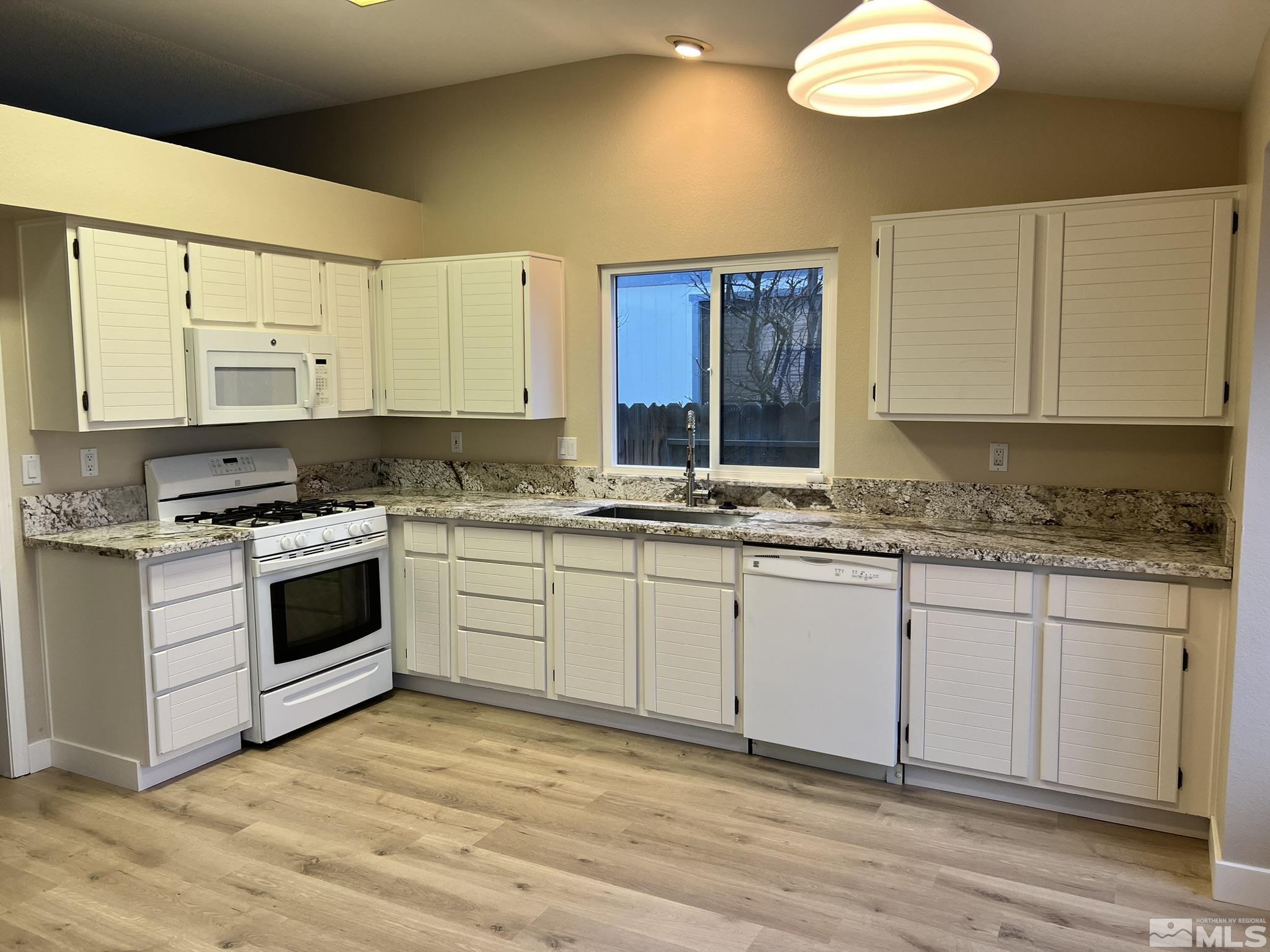 5267 Simons Drive Reno, NV 89523 - Photo 6 of 33 a kitchen with granite countertop a stove a sink and a refrigerator