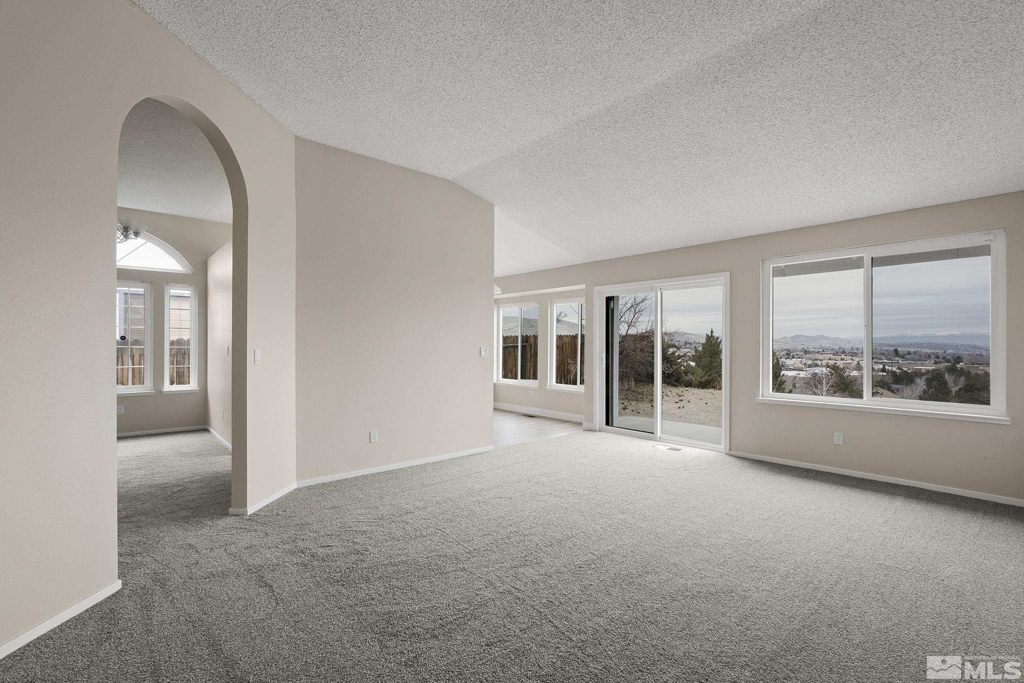 5267 Simons Drive Reno, NV 89523 - Photo 10 of 33 an empty room with large windows and a yard