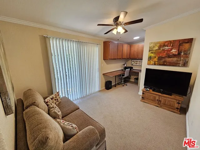 a living room with furniture a ceiling fan and a window
