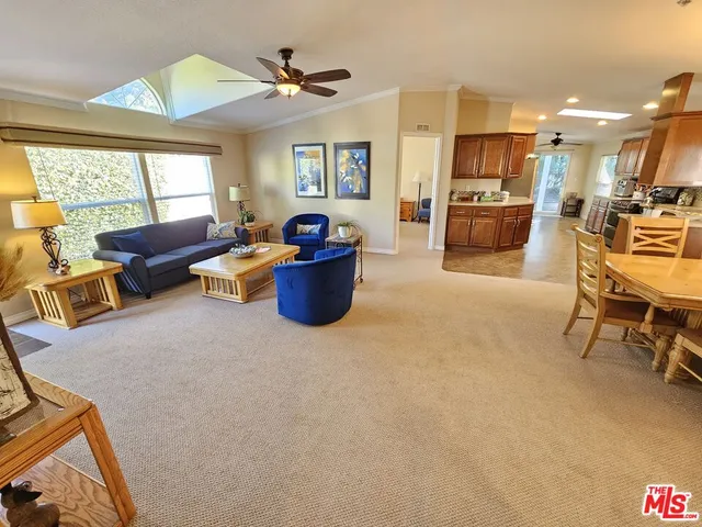 a living room with furniture a flat screen tv and a large window