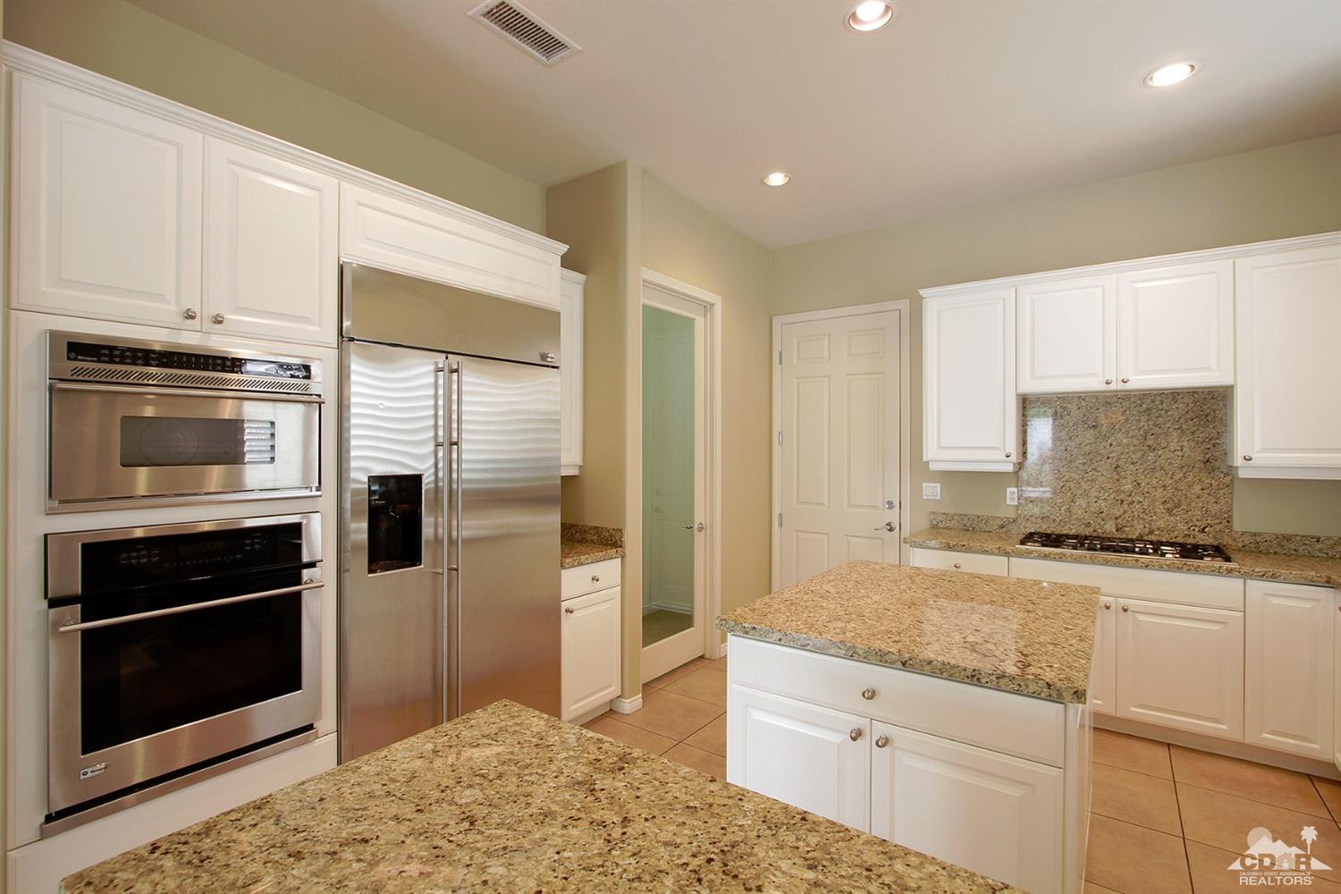 4 Orleans Road Rancho Mirage, CA 92270 - Photo 15 of 35 a kitchen with granite countertop a refrigerator and stove