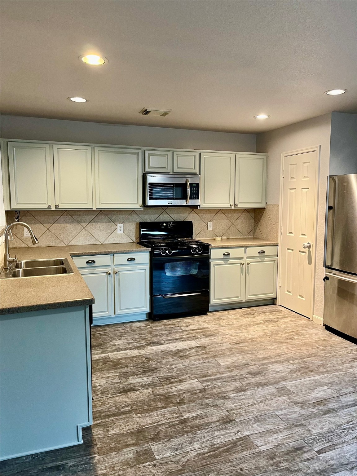 2655 Skyview Shadows Court Houston, TX 77047 - Photo 3 of 9 a kitchen with stainless steel appliances granite countertop a stove top oven a sink and a refrigerator
