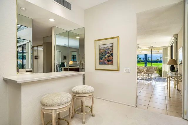 a kitchen with a sink and chairs