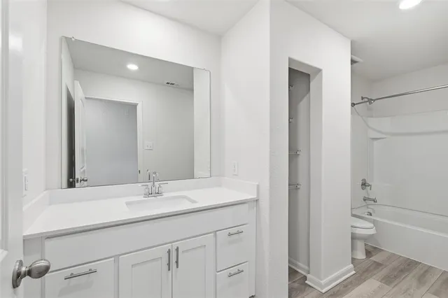 a bathroom with a sink a toilet and a large mirror