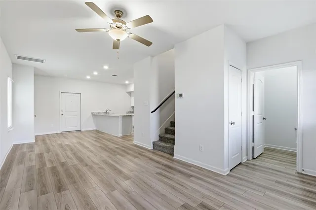 a view of a kitchen with wooden floor and a ceiling fan