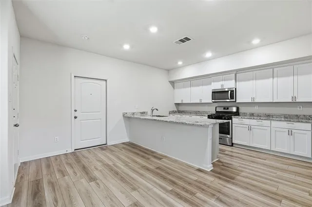 a kitchen with stainless steel appliances granite countertop a sink and cabinets