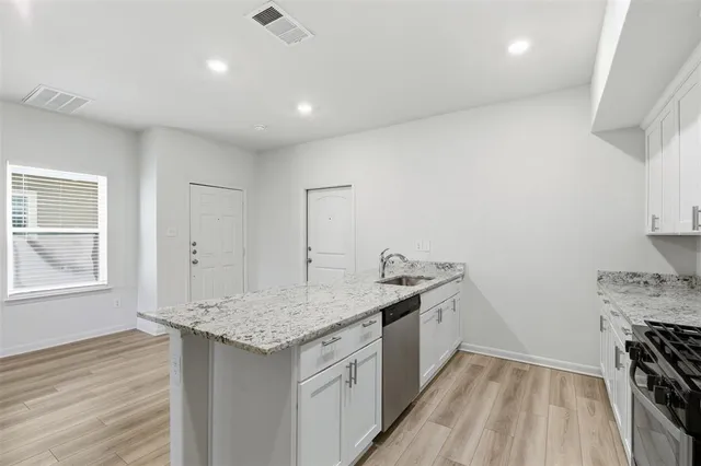a kitchen with a sink stove and cabinets