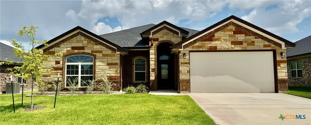 a view of a brick house with a large windows and a yard