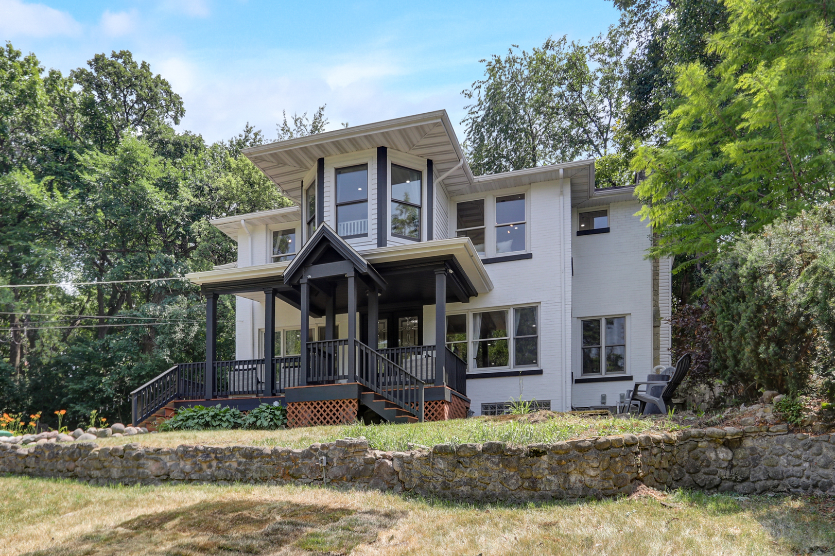a front view of a house with a tree