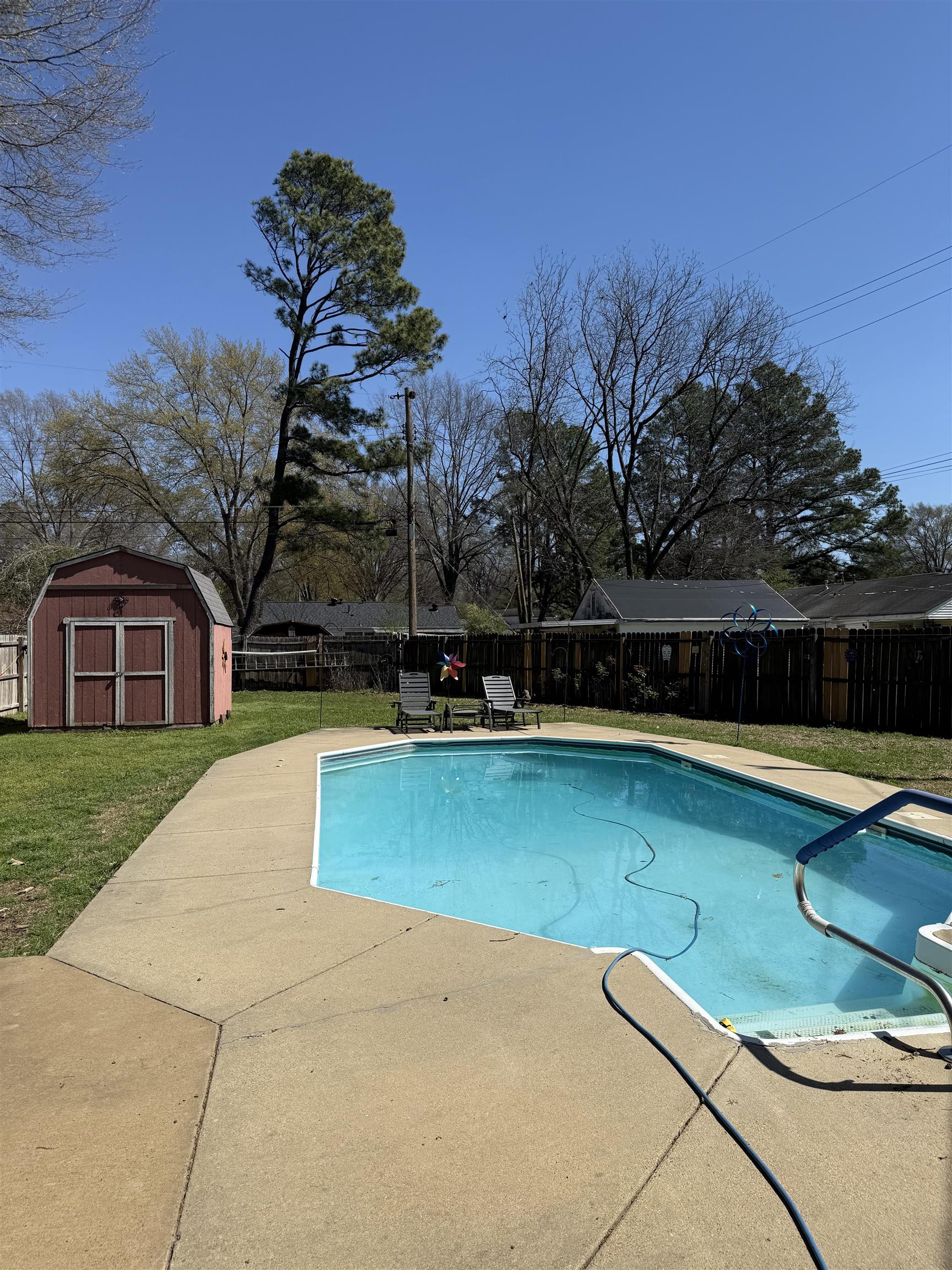 1332 Wells Station Road Memphis, TN 38108 - Photo 2 of 23 View of swimming pool featuring a fenced backyard, a shed, and patio surround