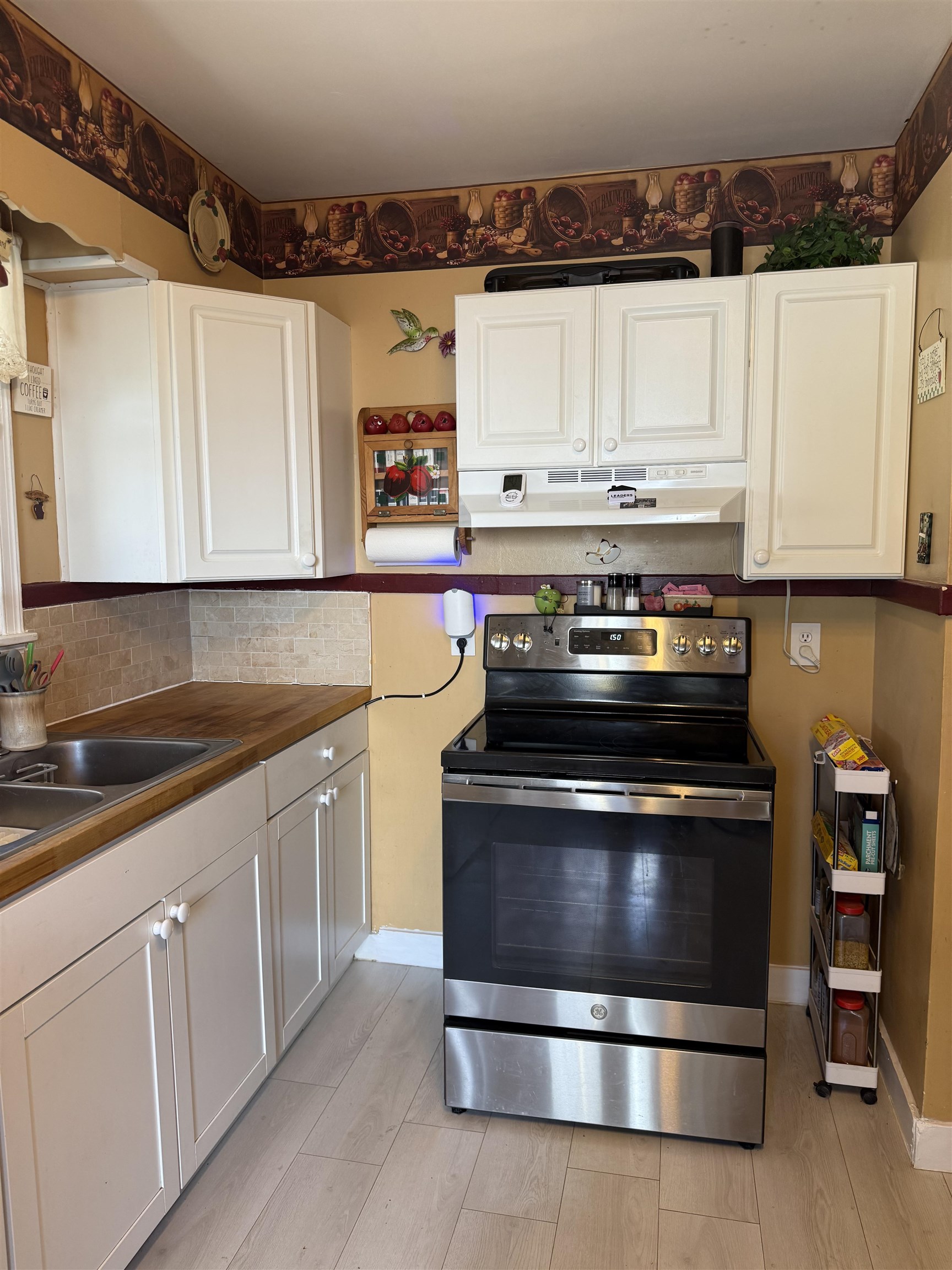 1332 Wells Station Road Memphis, TN 38108 - Photo 5 of 23 Kitchen with stainless steel electric stove, white cabinets, butcher block counters, and backsplash