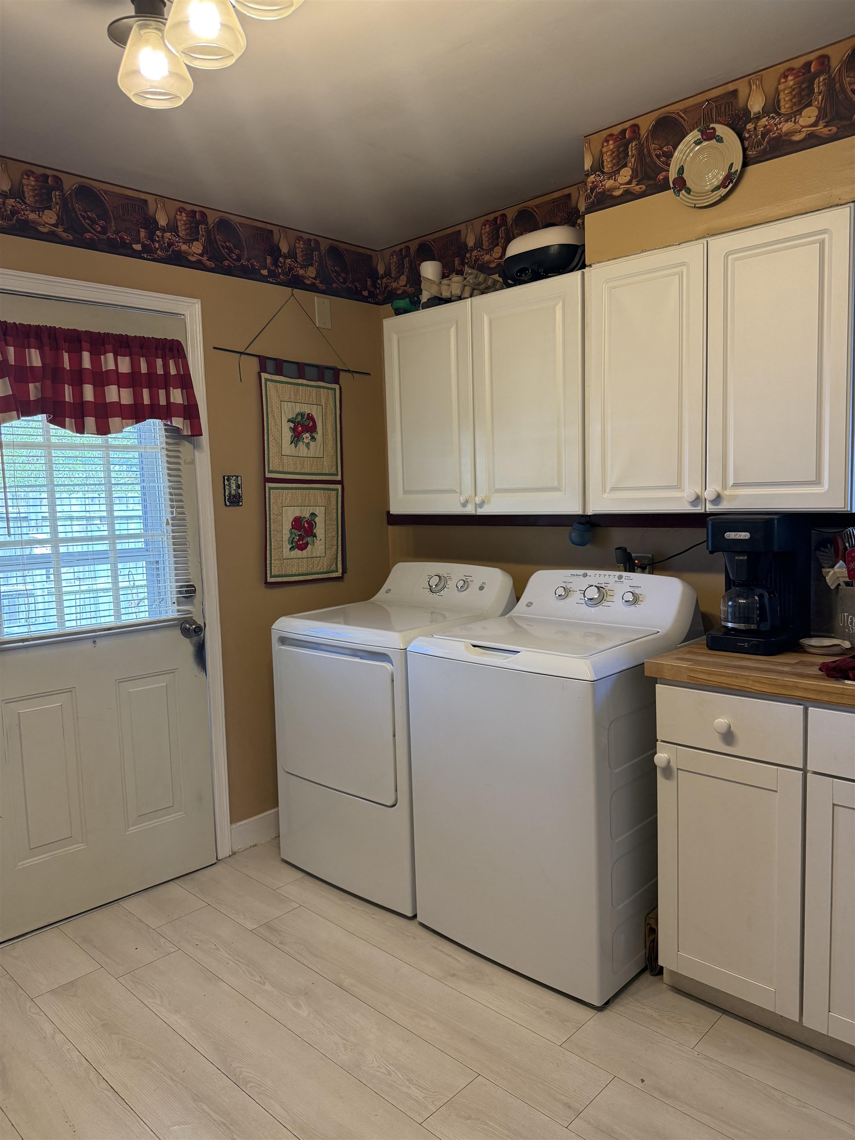 1332 Wells Station Road Memphis, TN 38108 - Photo 6 of 23 Laundry area featuring light wood-style flooring, cabinet space, and washer and clothes dryer