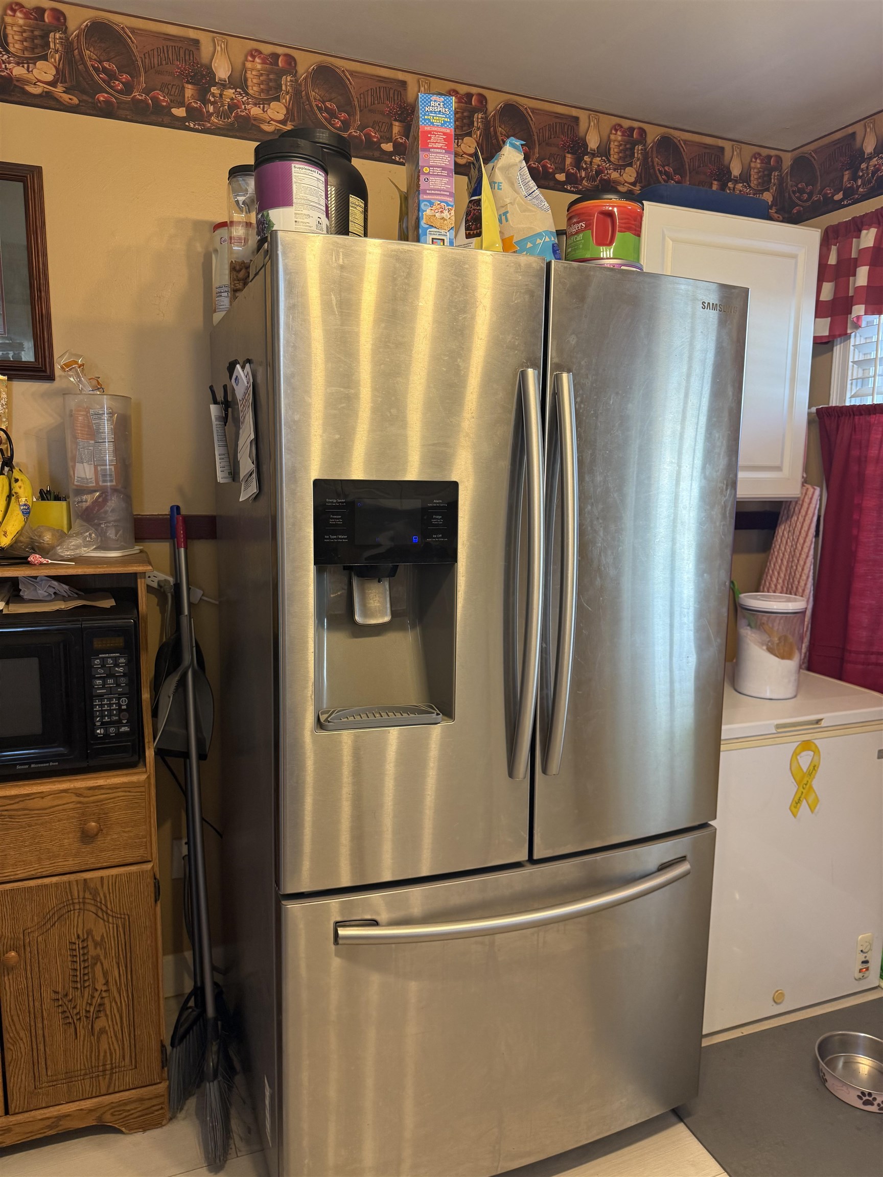 1332 Wells Station Road Memphis, TN 38108 - Photo 7 of 23 Kitchen featuring stainless steel refrigerator with ice dispenser, black microwave, light countertops, and white cabinets