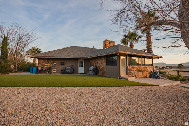 980 Cactus Circle St. George, UT 84790 - Photo 54 of 77 Back of property featuring a chimney, a patio area, and a lawn