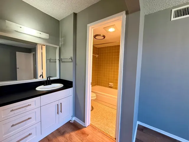 a bathroom with a granite countertop sink and a mirror