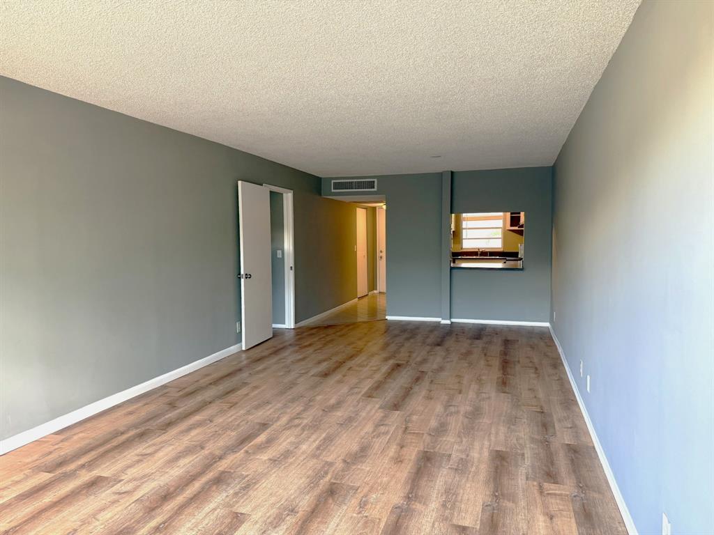 9450 Live Oak Place, Unit 303 Davie, FL 33324 - Photo 8 of 24 a view of empty room with wooden floor and fan