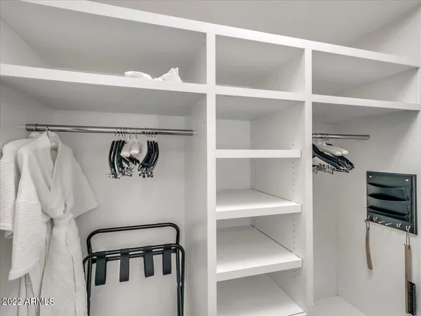a view of walk in closet with clothes and shoes