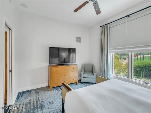 a bedroom with a bed and a flat tv screen on the dresser