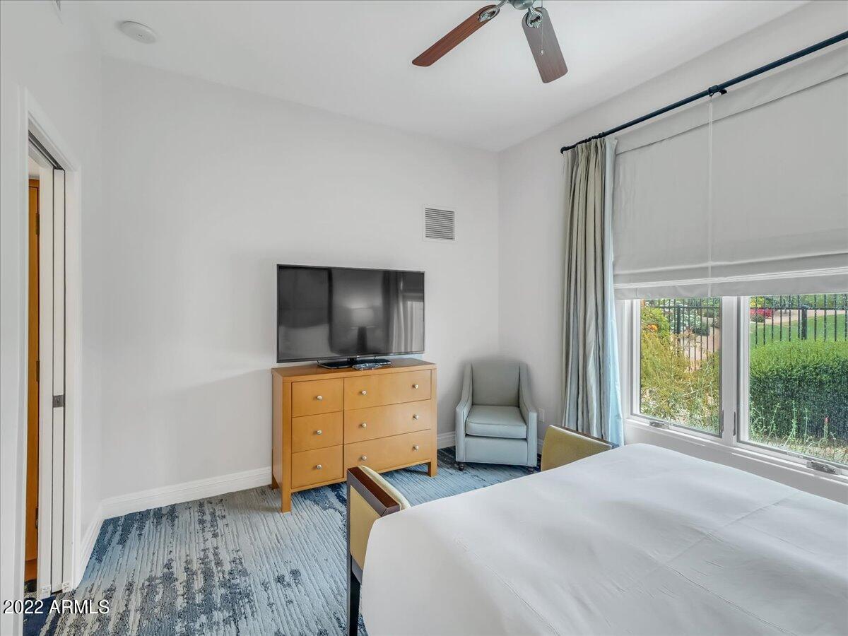 6000 East Camelback Road, Unit 7707 Scottsdale, AZ 85251 - Photo 24 of 42 a bedroom with a bed and a flat tv screen on the dresser