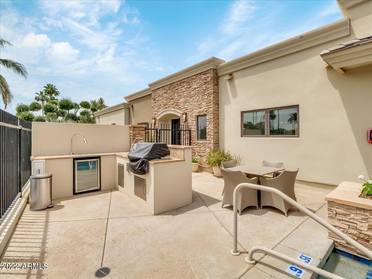 6000 East Camelback Road, Unit 7707 Scottsdale, AZ 85251 - Photo 32 of 42 a backyard of a house with barbeque oven and outdoor seating